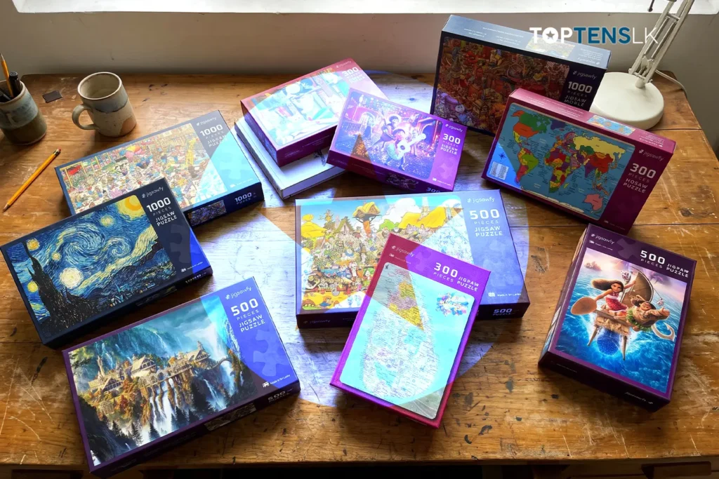 Jigsawfy puzzle boxes arranged on a wooden desk, including Asterix, Moana, maps and Starry Night